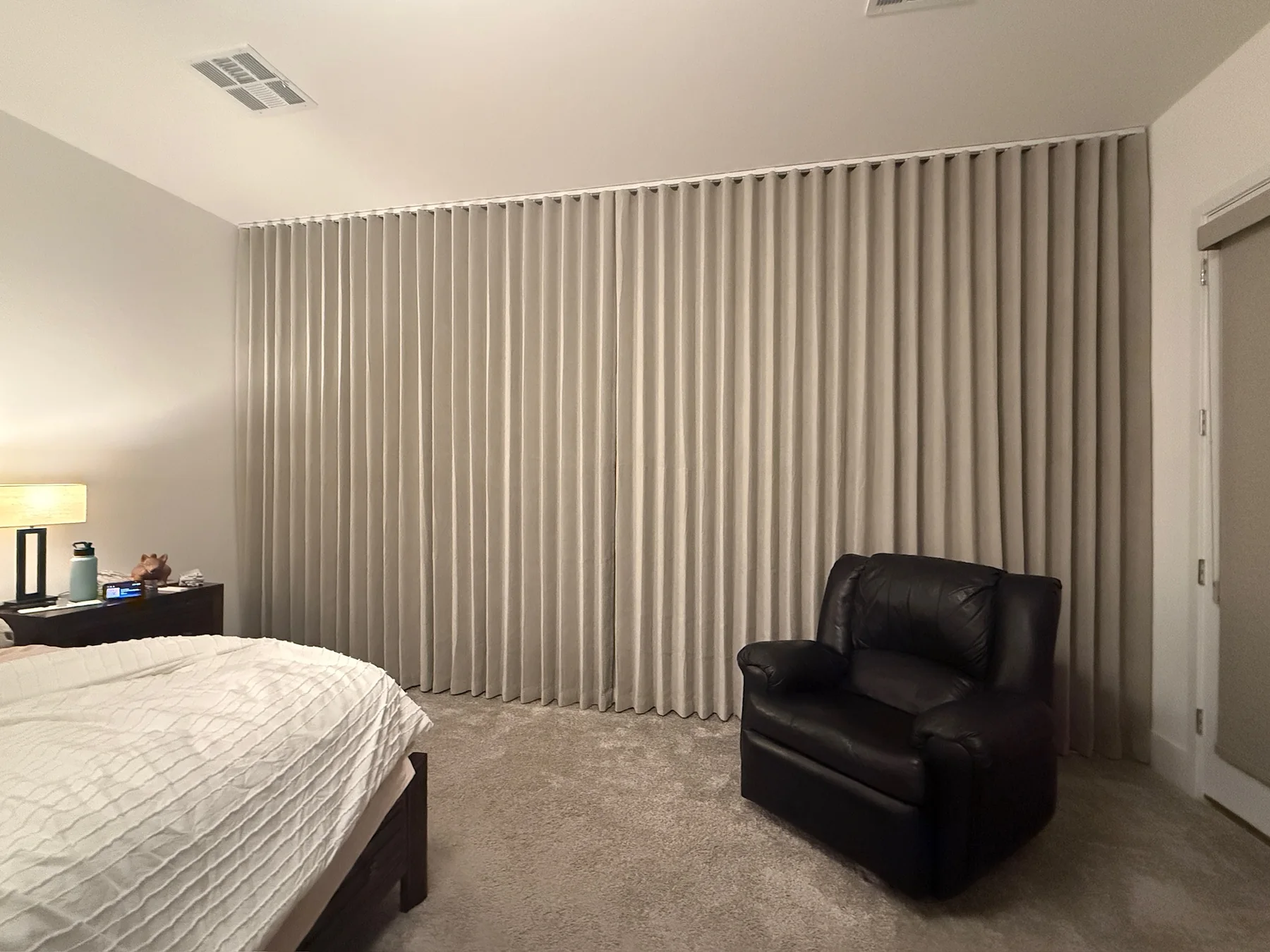 Full wall neutral drapery in a bedroom