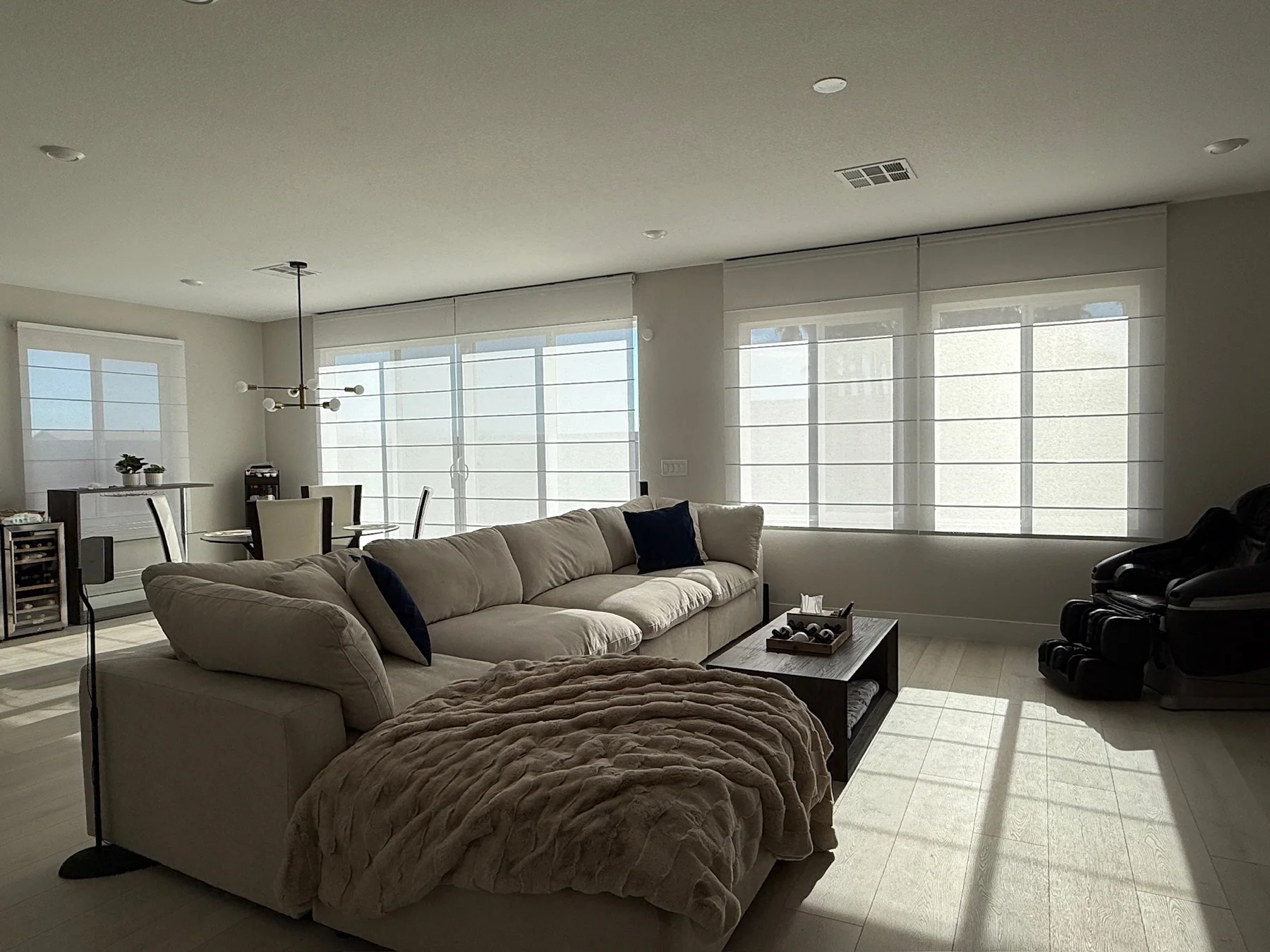 Roman shades installed across a bright open living room